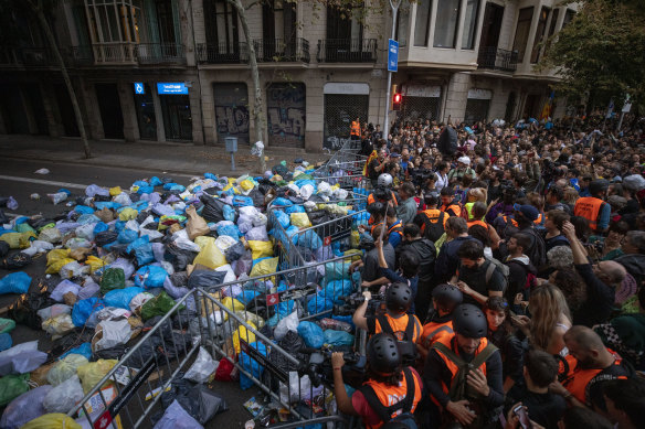 Catalan pro-independence demonstrators gather after dumping garbage bags in front of a government building.