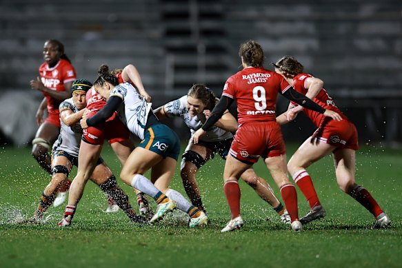 Maya Stewart tackles Claire Gallagher of Canada in a sodden Test match in Sacramento.