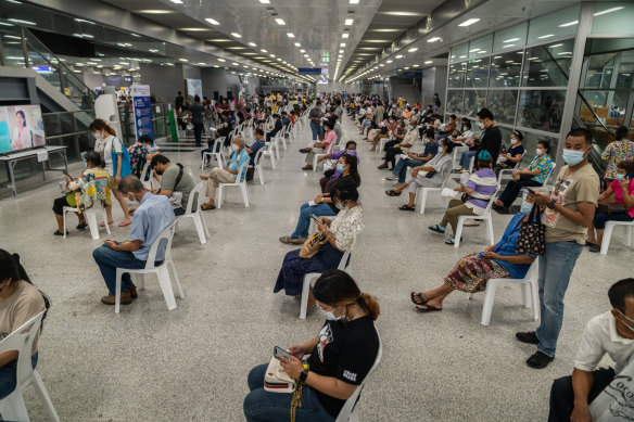 People wait in an observation area after being administered AstraZeneca at a vaccination centre at Bang Sue Grand Station in Bangkok.