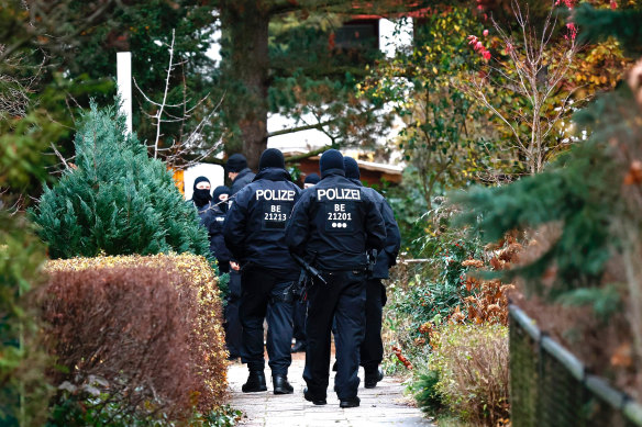 Police walk to a residence that they raided earlier today in Berlin, Germany. 