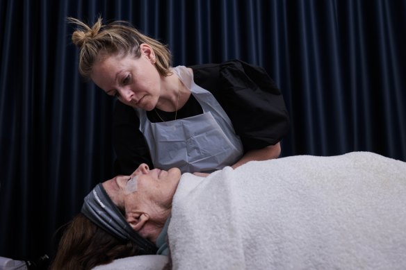 TAFE student Courtney Robinson gives her client Leslie Walker an eyelash tint at TAFE’s Northern Beaches campus.