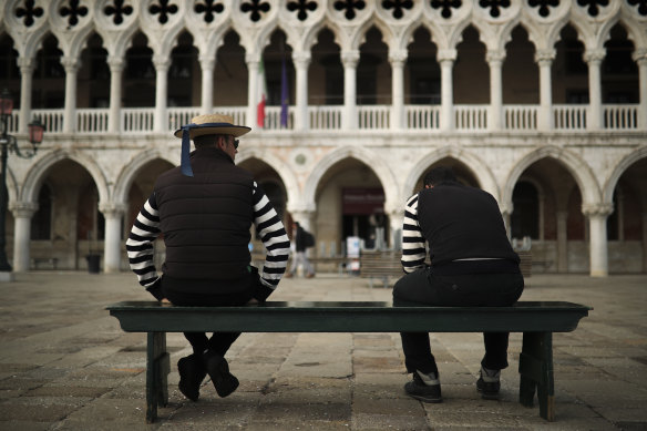 Gondoliers wait for customers near St Mark's square in Venice, Italy during the lockdown.