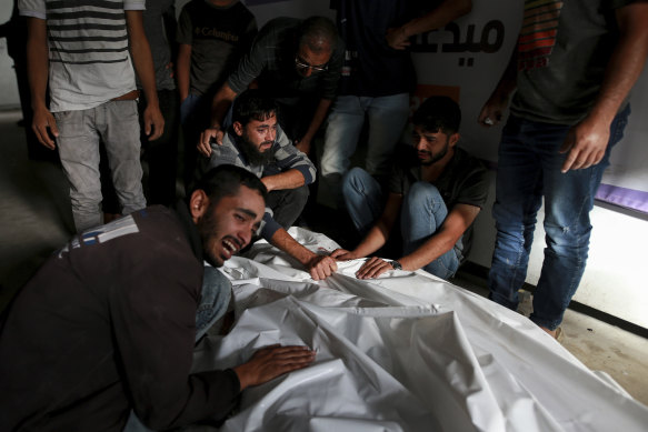 Palestinians mourn over the bodies of relatives killed in an Israeli airstrike, at a morgue in Rafah.