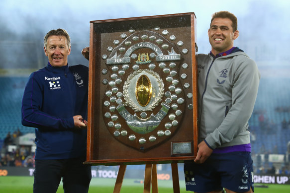 Storm coach Craig Bellamy and Dale Finucane of the Storm pose with the JJ Giltinan Shield in 2021.