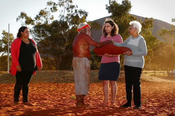 Mutitjulu elder Rolley Mintuma presents the Uluru Statement inside a piti to Teangi Brown and Irene Davey during the closing ceremony of the national convention in May 2017.