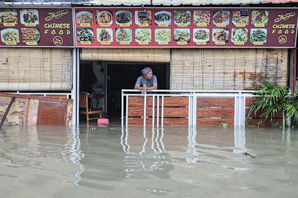A man looks out from his flooded restaurant in Legian, Bali, in February.