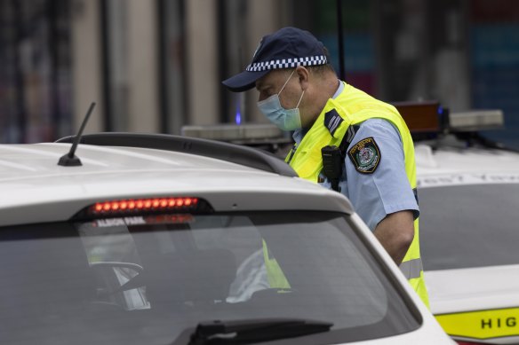 A police officer check’s a driver’s identification at a roadblock in Sydney.