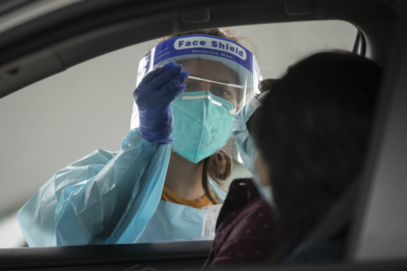 A health worker carries out a COVID-19 test at the Merrylands drive-through clinic in Sydney.
