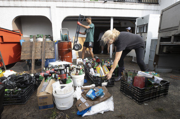 Restaurant owner Sarah Newson, right, cleans the flood damage at her business in Auckland.