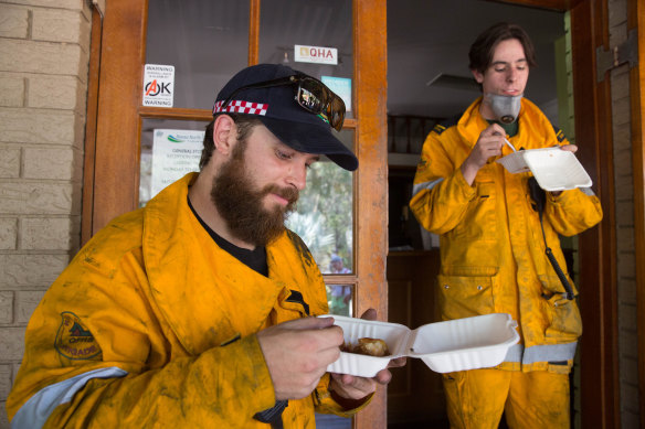 Firefighters eating lunch in the suburb of Noosa North Shore in Queensland on Wednesday.