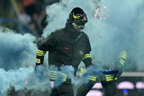 A firefighter removes flares from the pitch following Napoli’s 1-1 draw in Udine.