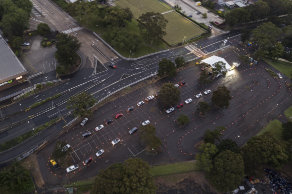 Cars queue at the Roselands drive-through COVID-19 testing clinic at dawn on Thursday. 