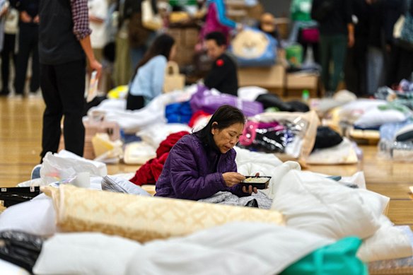 A resident rests at a temporary shelter near the fire scene at Wang Fuk Court.