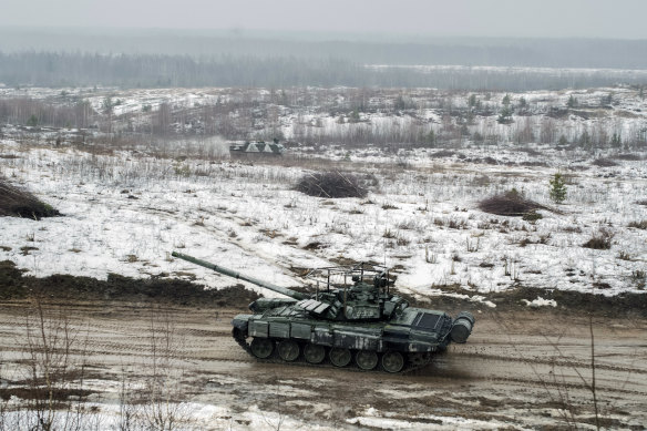 A tank moves through a muddy field during joint military exercises with Russia in Osipovichi, Belarus, on February 17, 2022. 