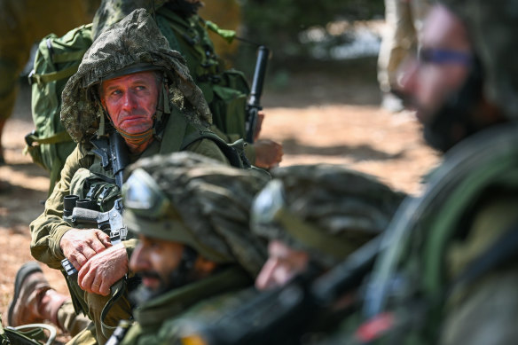 An Israeli soldier rests with fellow troops at a kibbutz near the Gaza border.