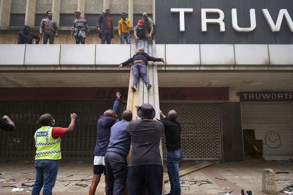 Children are evacuated from a burning building in downtown Durban, South Africa, on Tuesday July 13.