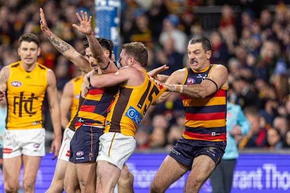 Taylor Walker of the Crows pulls Blake Hardwick of the Hawks.