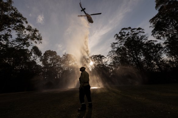 Wollombi RFS Captain Rob Tulloch calls in a water bombing helicopter to the Kearsley fire.