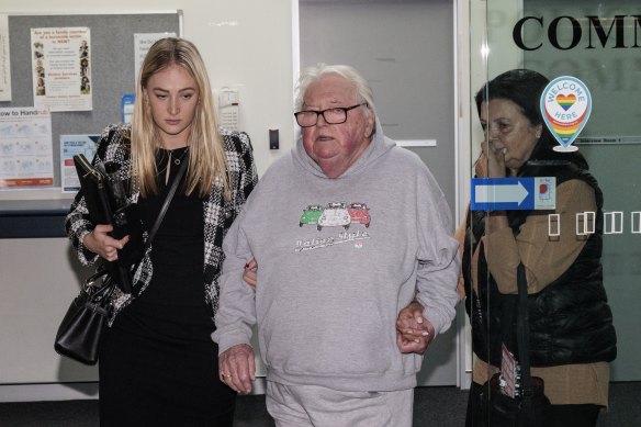 Dick Caine (centre) leaves Bankstown police station in June.