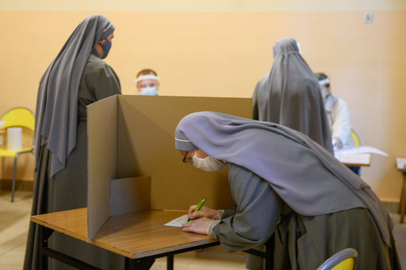 A nun wears a protective face mask as she casts her ballot during Poland's Presidential elections in Krakow, Poland. 