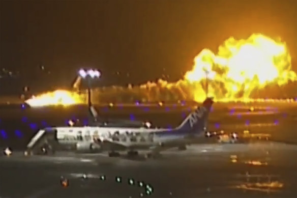  A Japan Airlines plane is seen on fire on the runway of Haneda airport in Tokyo, Japan. 