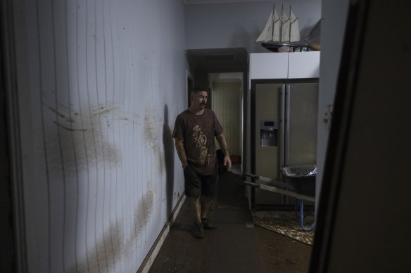 Matt Cutting stands amongst the ruins of his home after flooding reach the second story. 