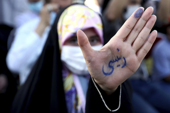 An Iranian voter shows the name Raisi written on her hand in Persian. 