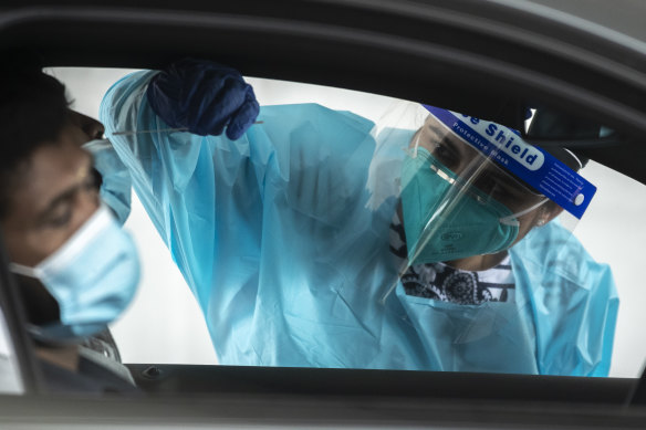 A health worker carries out a COVID-19 testing at the Merrylands drive-through clinic in Sydney.