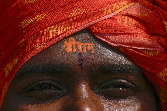 A Hindu devotee has the words Sri Ram’ written on his forehead as he watches in Hyderabad, India, a live telecast of inauguration of a temple. Hindus were encouraged to celebrate the opening of the temple around the world, including in Australia.