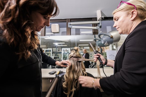 TAFE teacher Cherie Lovett supervises student Jenny Eady as she styles her client’s hair.