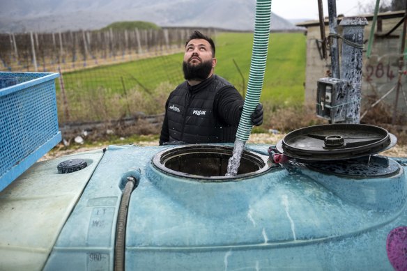 Farmer Dimitris Kakalis, 25, fills a water tank and worries about paying for basic supplies. “We’re headed for ruin”. 