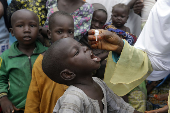 Nigeria - where a polio vaccine is pictured being administered to children - is predicted to become an economic powerhouse.