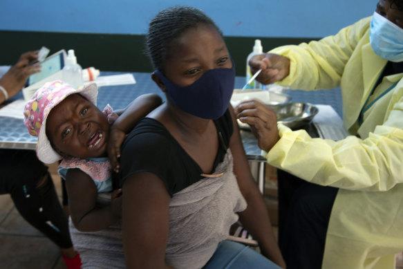 A baby cries as her mother receives her Pfizer vaccine against COVID-19, in Diepsloot Township near Johannesburg. A new COVID-19 variant has been detected in South Africa.