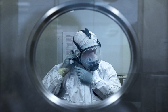 Associate Professor Stuart Turville dons protective equipment before starting to work with COVID-19 variants.