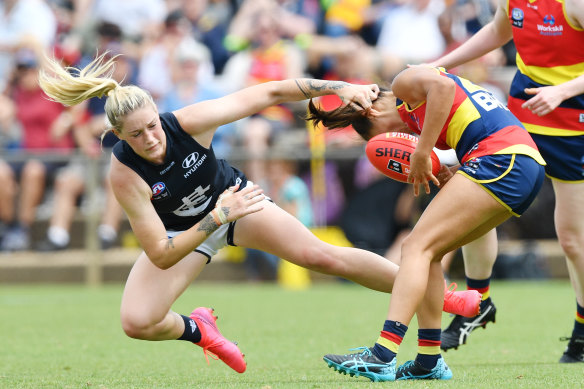 Justine Mules attempts to shrug a Tayla Harris tackle.