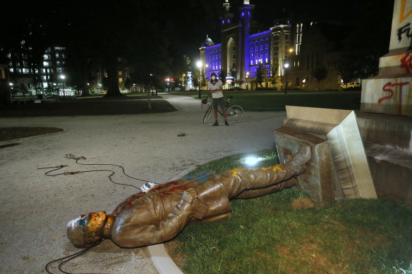 The statue of Confederate General Williams Carter Wickham lies on the ground after protesters pulled it down. The statue had stood in the park since 1891. 