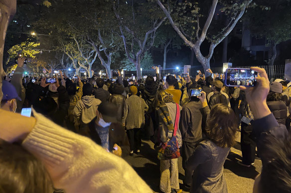 Residents gather on Middle Urumqi Rd, Shanghai to mourn victims of a fire in the city of Urumqi, Xinjiang.