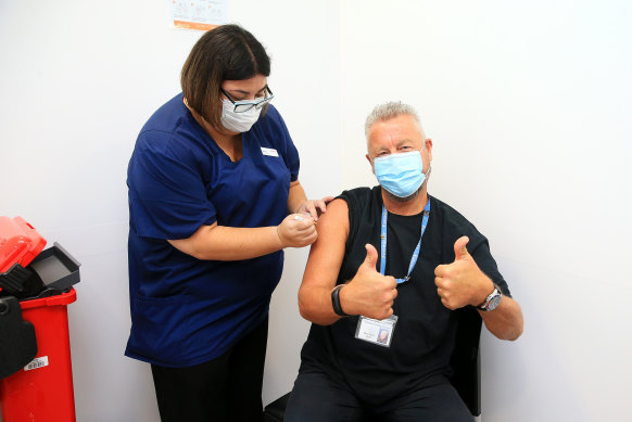 Dr Chris Quinn, who has been working in hotel quarantine, receives one of the first Pfizer COVID-19 vaccines at Austin Health, administered by nurse Jessica Amalfi.