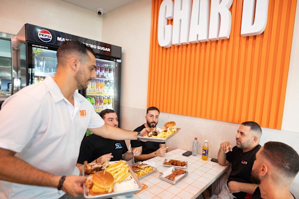 James Estephan serves customers at his newly opened Char’d Lebanese chicken shop in Belfield, Sydney.