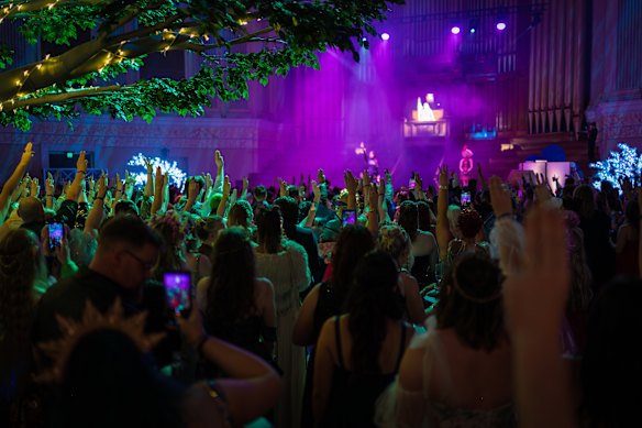 Ball attendees do the three-finger salute from the Hunger Games series.