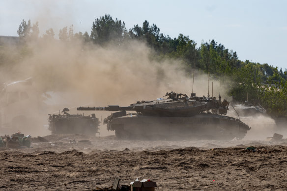 An Israeli tank moves through the sand as Israel prepares for a ground invasion of the Gaza Strip.