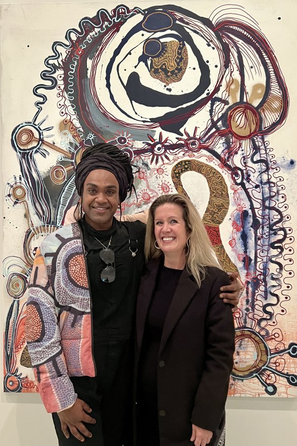 Wynne Prize winner Zaachariaha Fielding (left) and APYACC general manager Skye O’Meara, in front of his Untitled 2020 painting at the National Gallery of Victoria.
