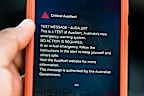 In this photo illustration, a critical AusAlert - Test Message notification appears on a smartphone July 27, 2026 in Sydney, Australia