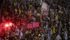 Families of hostages and supporters hold photos of hostages and flags during a rally against Prime Minister Benjamin Netanyahu in Tel Aviv. 