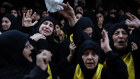 Relatives mourn the death of a Hezbollah fighter at his funeral in Beirut.