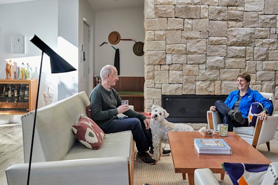 Patrick and Elizabeth Mitchell in their living room with its stone fireplace. The vintage suite is from Metro Road Trading.