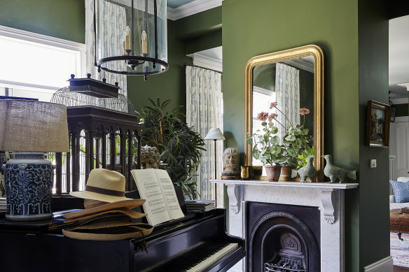 Baker had the baby grand piano she played as a child in England shipped to Australia. This room also features her collection of bird cages, plus a pendant light and vintage rug from Isla Design.
