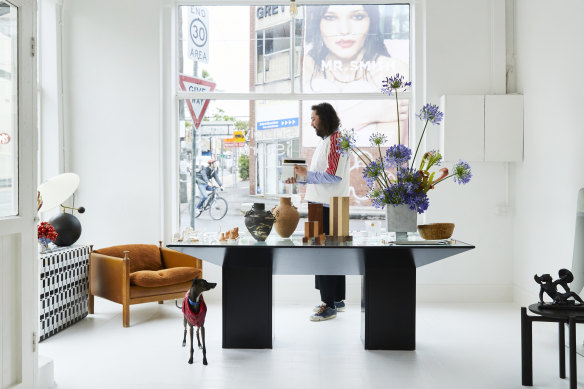 Ben Mooney with his greyhound, Goody, in the front room of his store. Local florist and designer Hattie Molloy designed the large “Ixia” vase and also created the agapanthus installation.