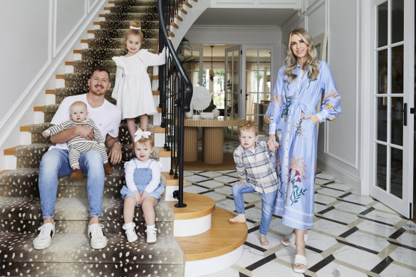 Tom Cahill, Georgia Bardoel and their young family on the staircase of their dream home.