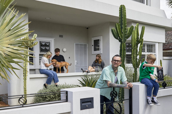 Taking cues from a curved wall in the former red-brick bungalow, the home was given a grand makeover incorporating the sleek P&O style. “It was crucial to add a second storey, as my older kids Frankie (on the porch with Caroline McCredie) and Clementine, need their own space,” says Ben Milgate, at the gate with Mac.